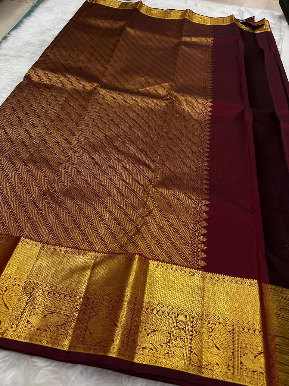Wide gold zari peacock-and-bird border close-up