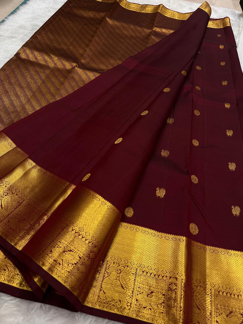 Gold zari peacock-and-bird pallu detail on maroon saree