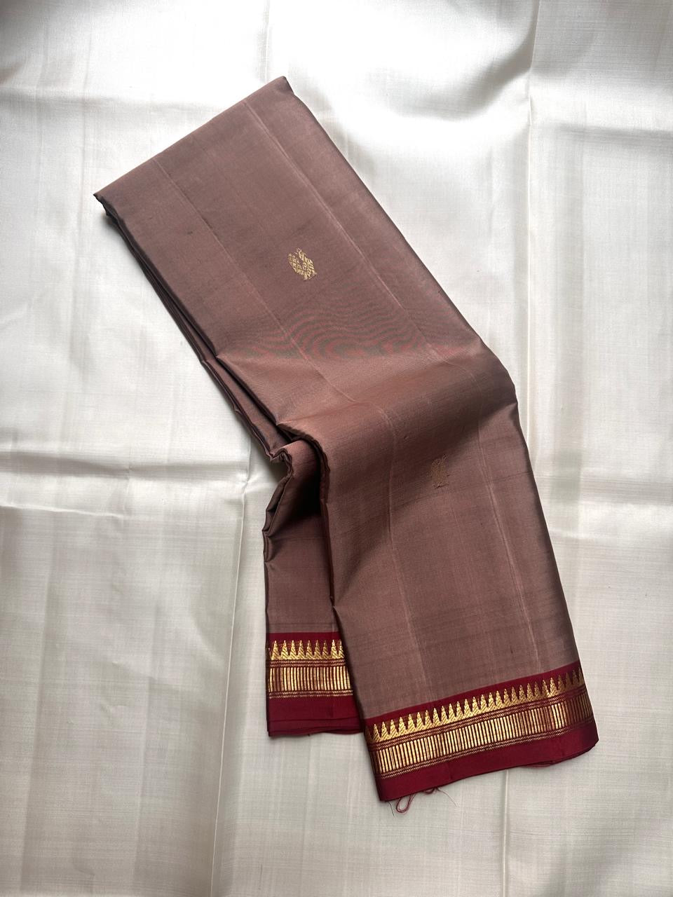Folded pure Kanchipuram silk saree in beige with narrow maroon border and metallic zari detailing available in the USA