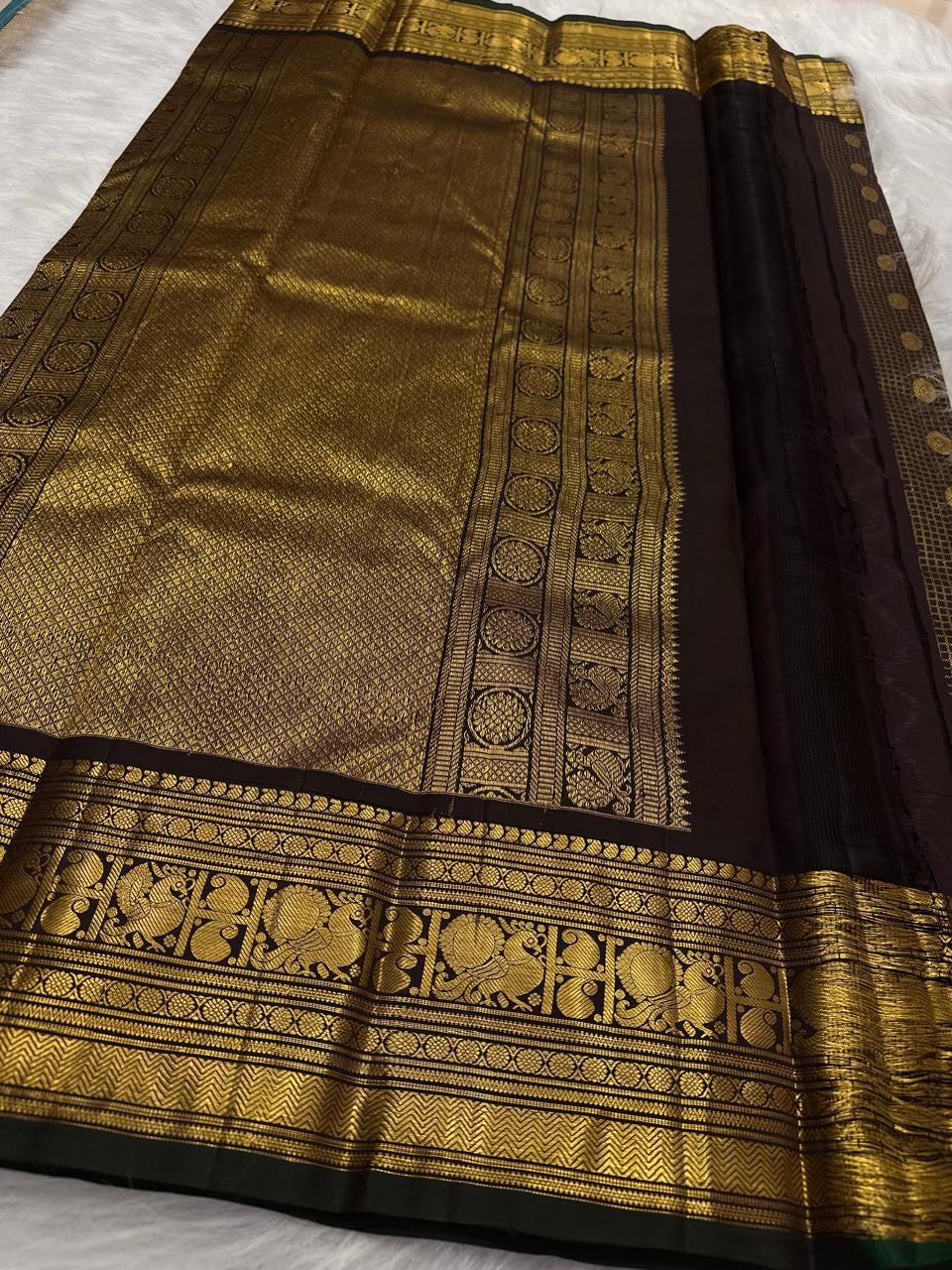 Self-colour pallu of deep brown lightweight Kanjivaram pure silk saree with cascading ornate antique gold zari array