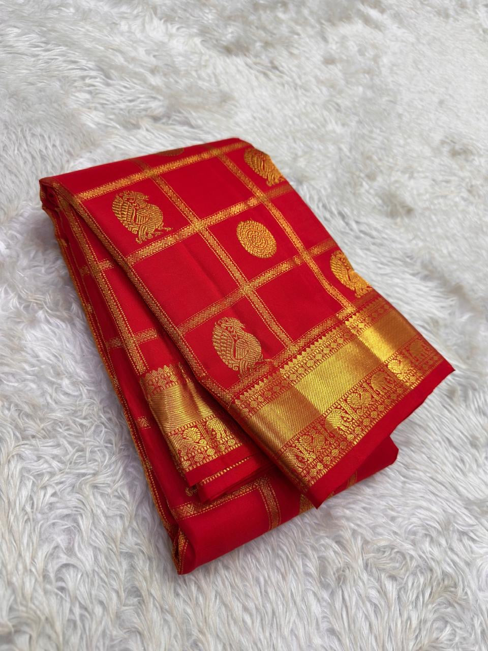 Mayil Chakram zari motif detail on the vermilion orange Kanchipuram saree