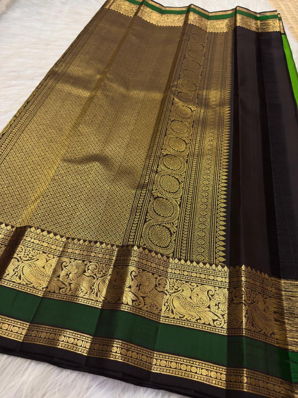 Stylised Mayil motifs and floral gold-zari detailing along the dark contrast border.