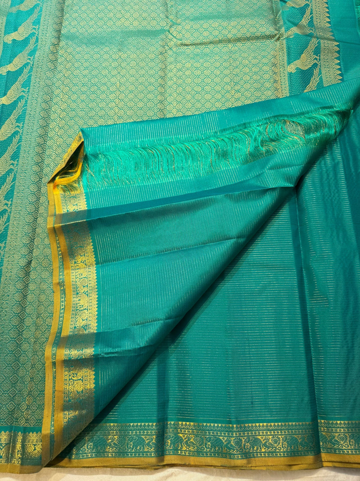 Peacock blue-green handwoven Kanchi Pattu Vairaoosi saree with large traditional bird zari motifs.