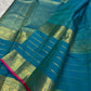 Peacock blue-green Kanchipuram silk saree with fine gold detailing and spaced zari motifs.