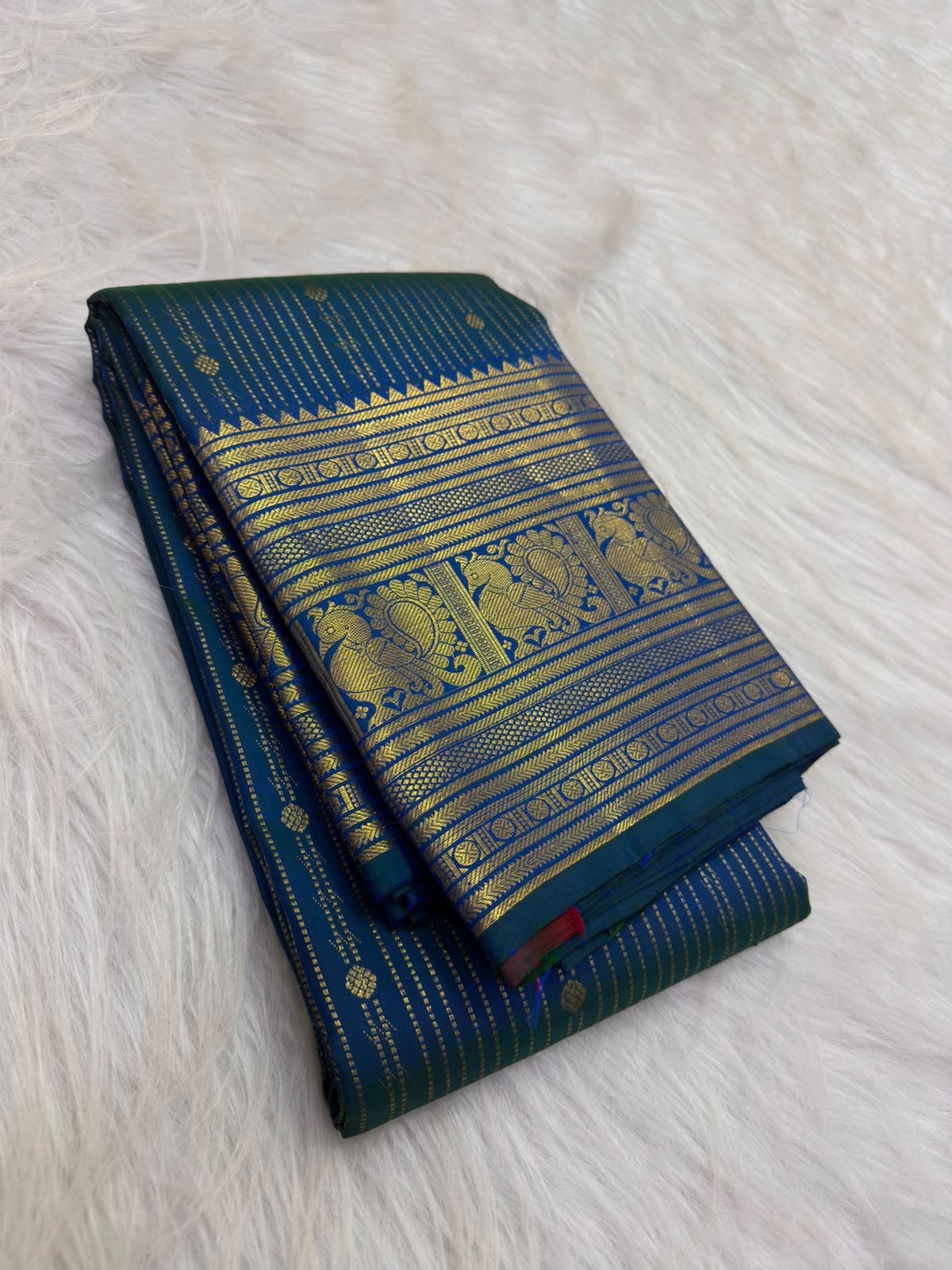Peacock blue-green Kanjivaram silk saree with fine vertical zari lines and petite gold buttas