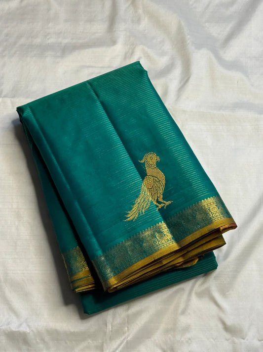 Close view of large antique-gold traditional bird motif on blue-green Kanchipuram silk.