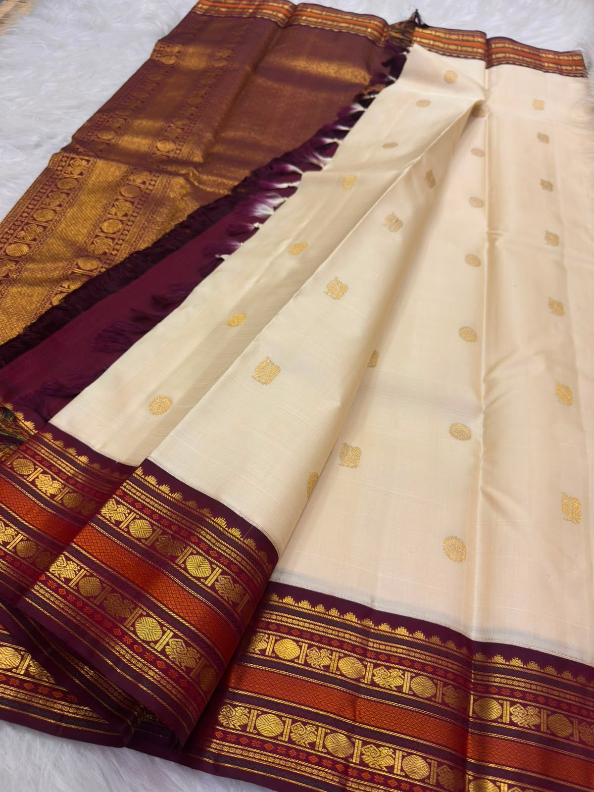 Mayil peacock and Thazampoo screwpine-flower motifs, warm-ivory Kanjivaram saree