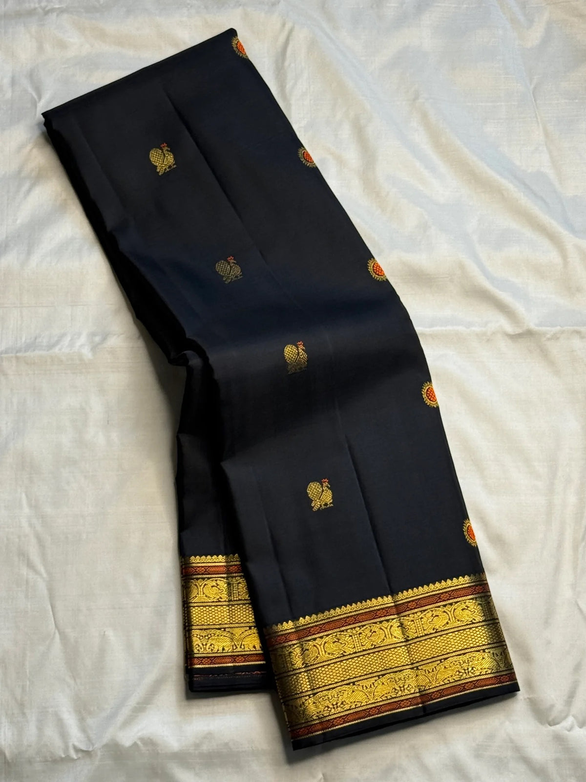 Detail of meenakari buttas woven across a black Pure Silk Kanjeevaram body.