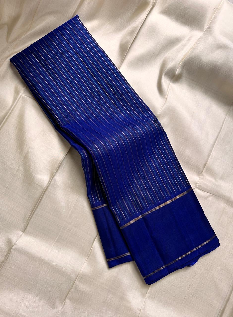 Deep royal indigo Kanchipuram silk saree with fine traditional zari stripe detailing and classic gold border folded view