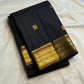 Black Kanchipuram silk body with gold and rust-accented meenakari buttas.