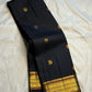 Black Pure Silk Kanjeevaram Butta saree with all-over meenakari buttas and a rich gold-zari border.