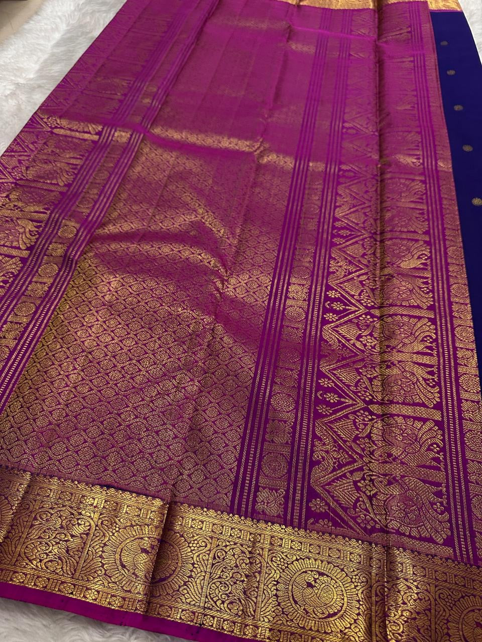 Vadamalli magenta-purple contrast border against the deep indigo KanchiPattu silk body.