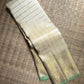 Warm Ivory Zari Kattam saree opened to show Kamalam buttas and elaborate Peacock and Benares Pettu border.