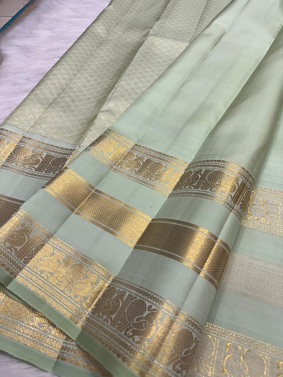 Mint Green Kanchipuram silk saree folded, showing border and pallu
