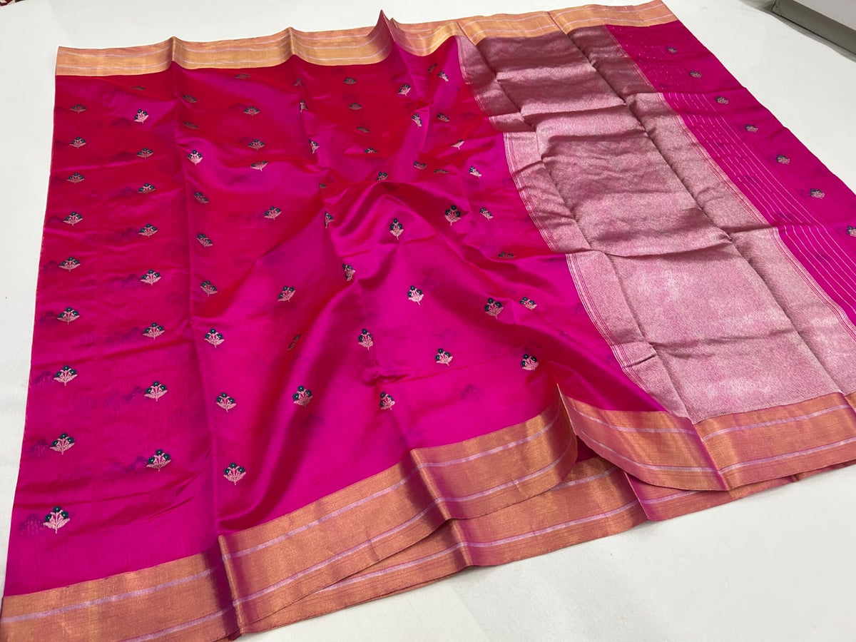 Rani pink Pattu silk Chanderi saree showing floral buttas, broad gold-toned border and shimmering pallu