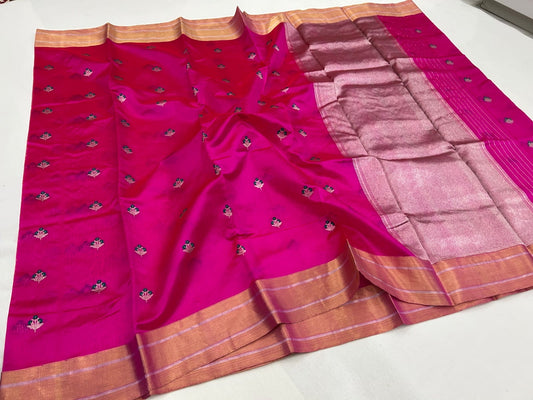 Rani pink Pattu silk Chanderi saree showing floral buttas, broad gold-toned border and shimmering pallu