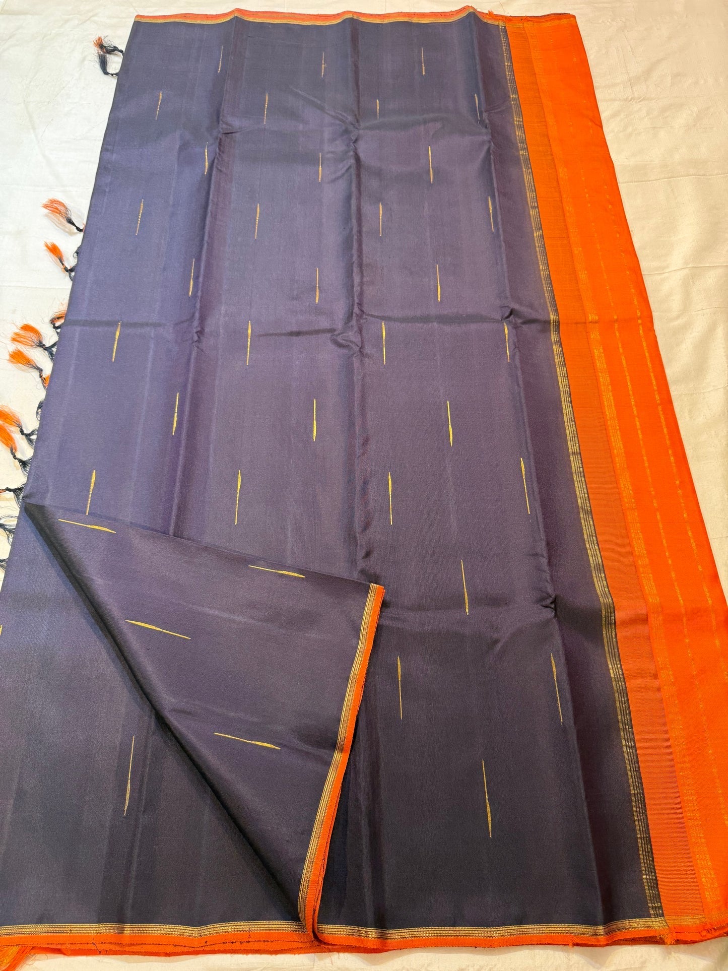 Deep aubergine brown Kanjivaram silk body with restrained gold zari buttas.