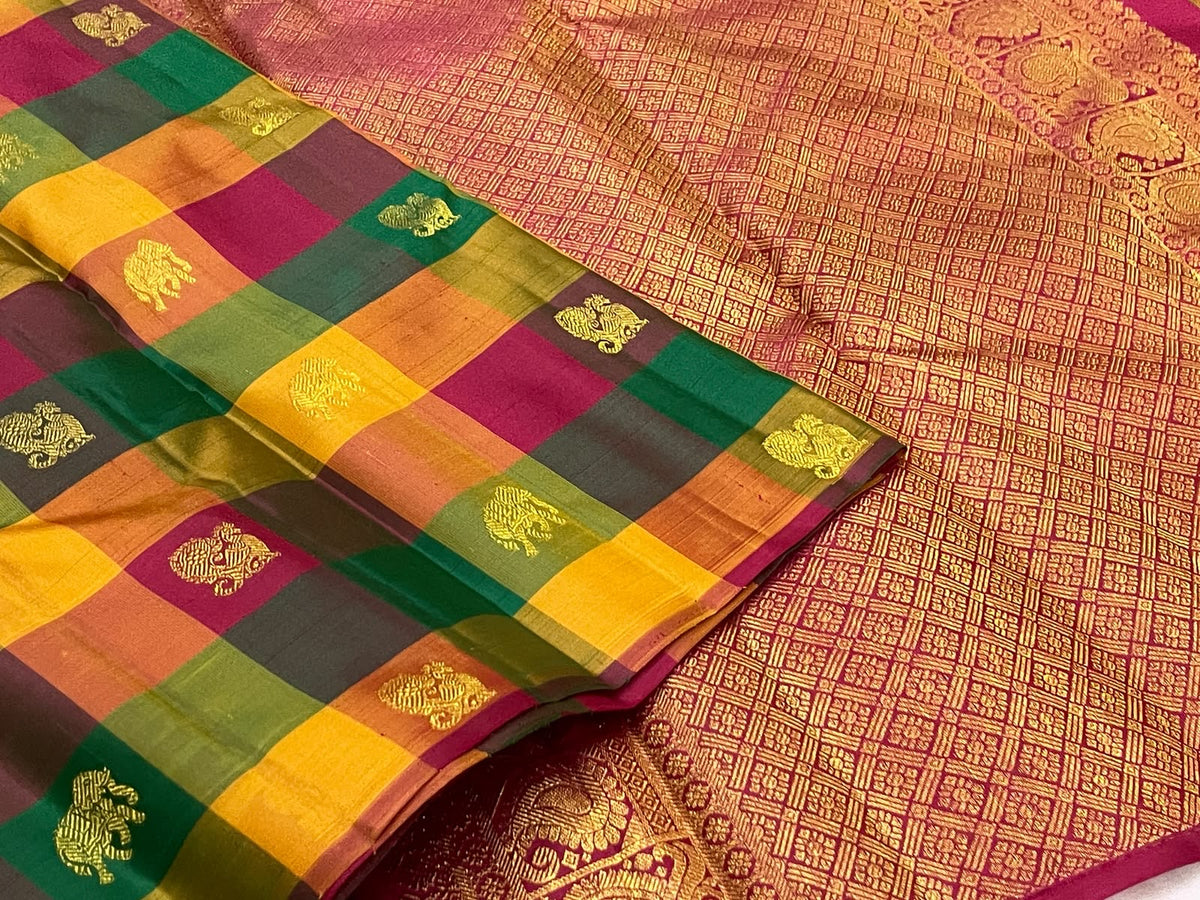 Folded multicolour Paalum Pazhamum Kanchipuram saree with checked silk squares and gold zari temple motifs.