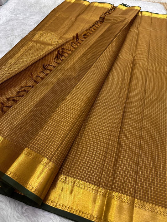 Diagonal zari woven pallu in antique gold cascading across mustard amber silk ground