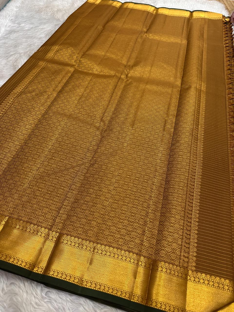 Mustard amber Kanchi Pattu saree folded to show Zari Kattam body and antique gold zari border