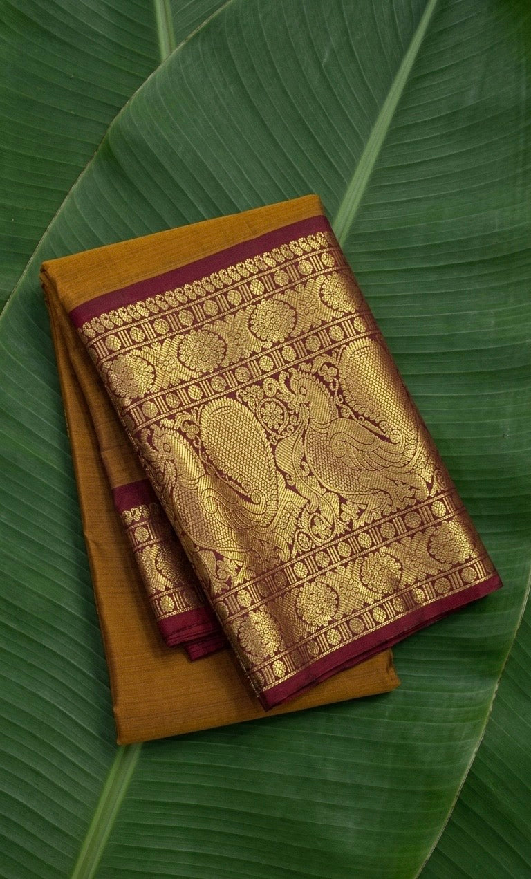 Mustard gold Kanchipuram silk saree with burgundy red korvai mayil border – front view
