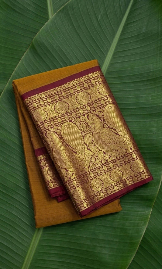Mustard gold Kanchipuram silk saree with burgundy red korvai mayil border – front view