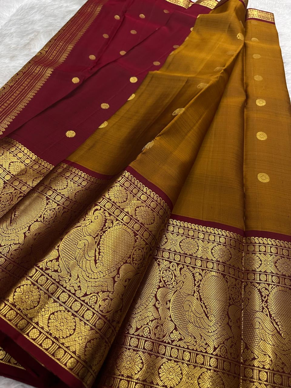 Mustard Kanjivaram saree with an ornate Arakku peacock border.