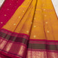 Close view of the golden-yellow silk body with open spacing between small zari buttas
