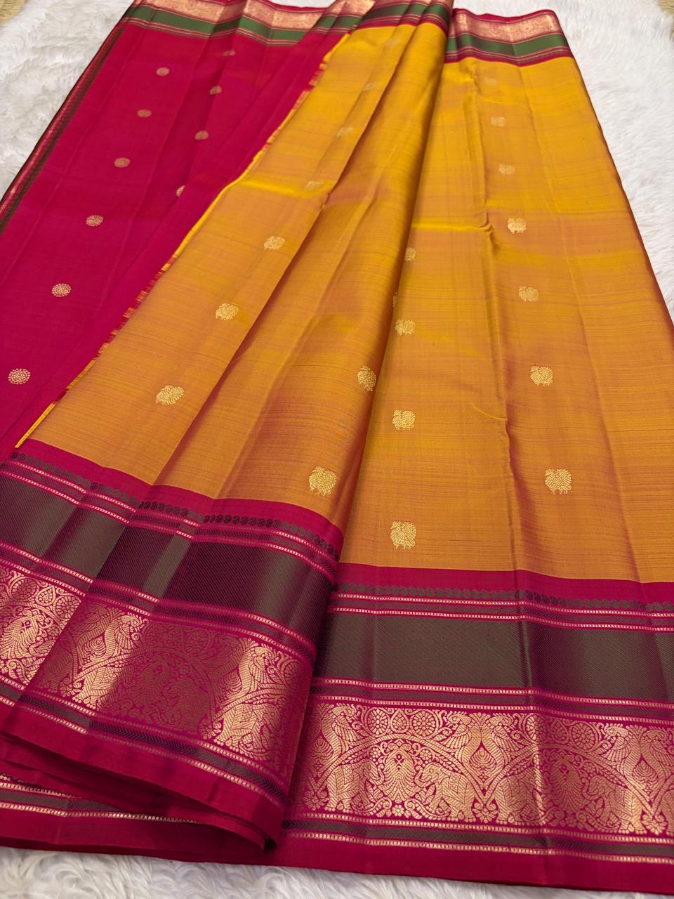 Close view of the golden-yellow silk body with open spacing between small zari buttas