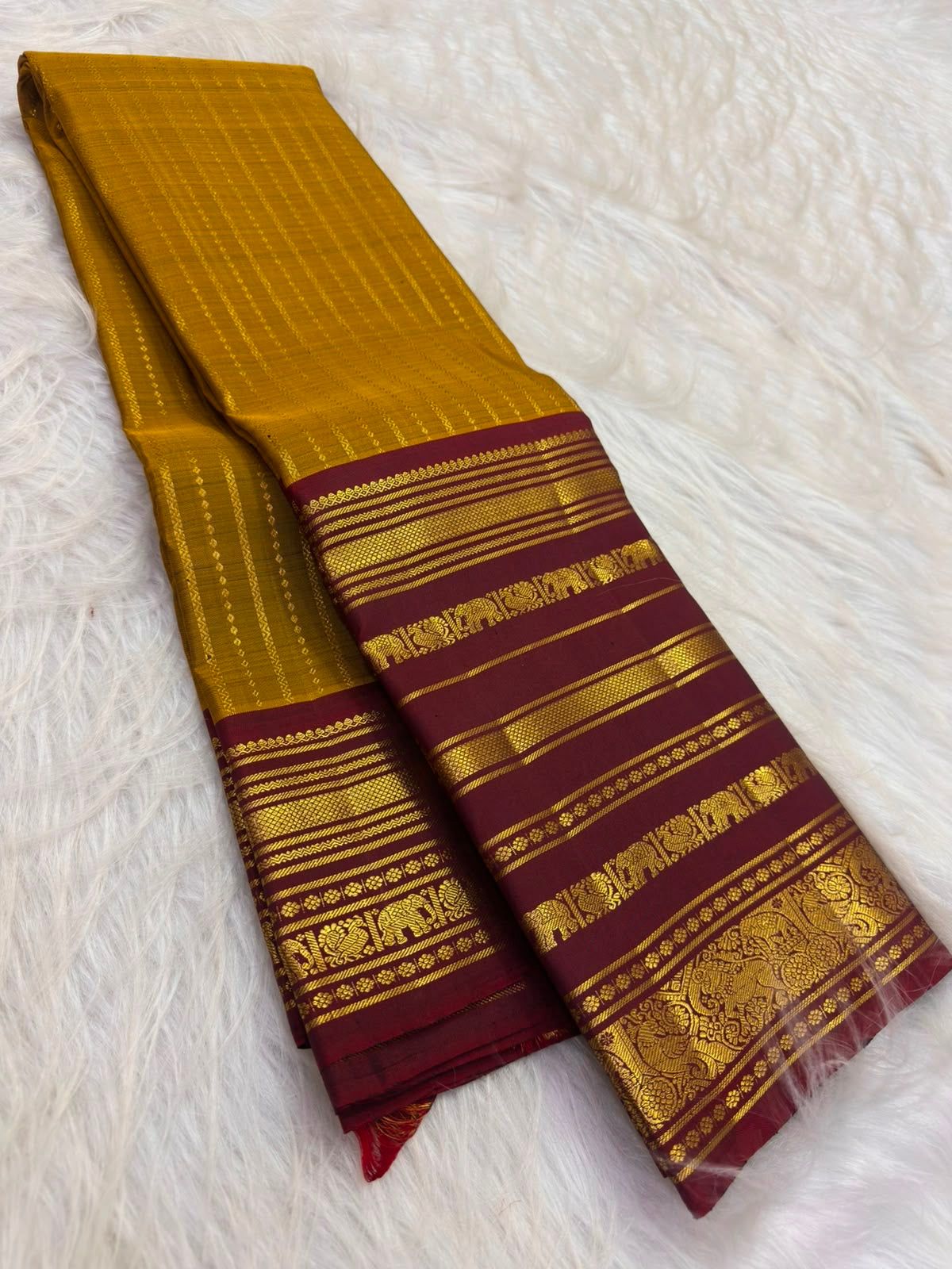 Deep Arakku Kanchipuram pallu showing dense geometric gold zari latticework and floral ornamentation.