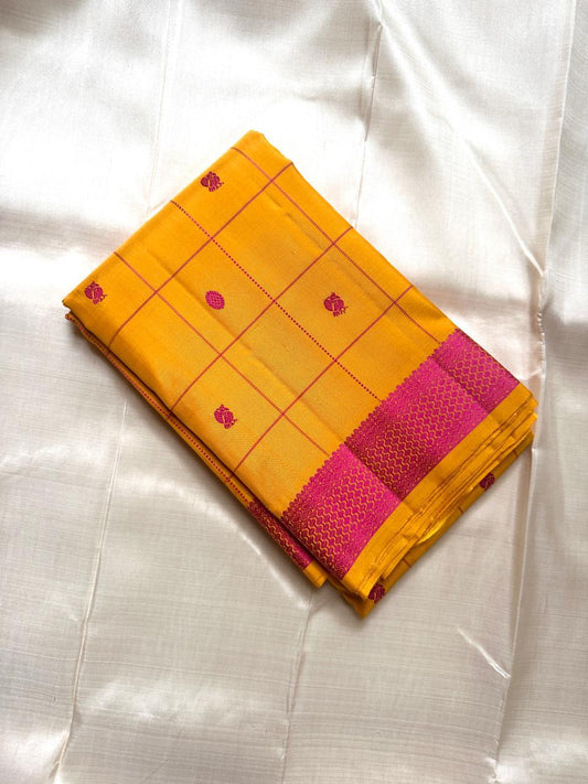 Folded mustard yellow Kanchipuram silk saree with magenta checks and magenta zari woven border