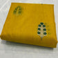 Yellow fabric with green floral embroidery on a white background