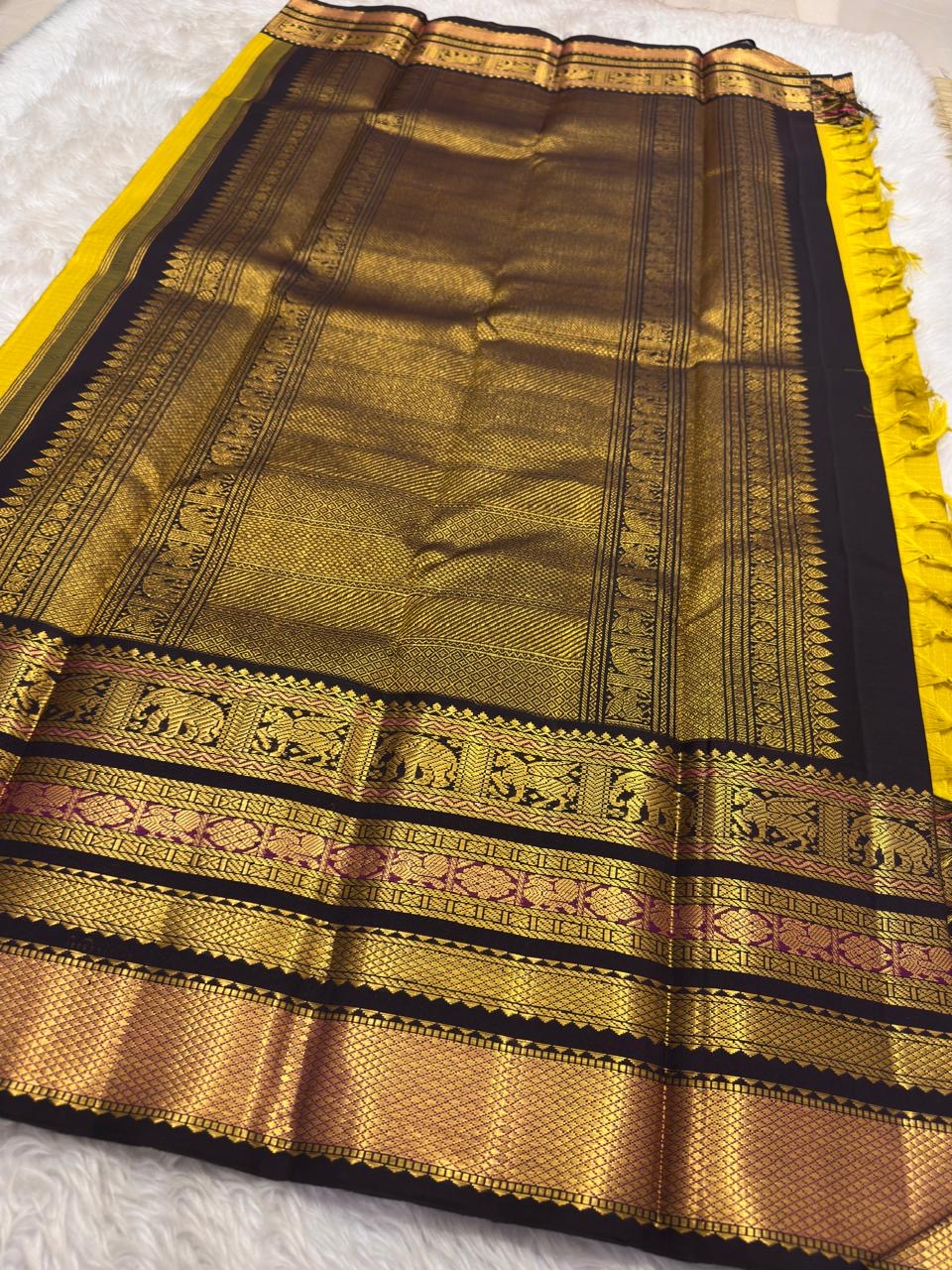 Close-up of mustard yellow silk body with luminous Zari Kattam grid and gold zari butta motifs