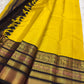 Mustard yellow Kanjipuram saree folded to show Zari Kattam body and contrast black border