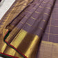 Muted purple-brown pure silk Kanchipuram saree with traditional zari motifs and gold lattice body.