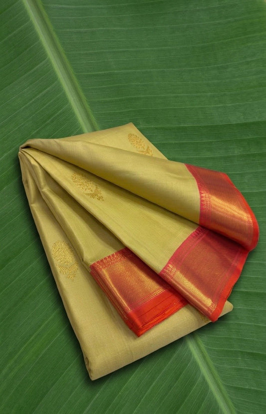 Muted turmeric beige Pure Kanchipuram silk saree with glowing sunset coral zari border