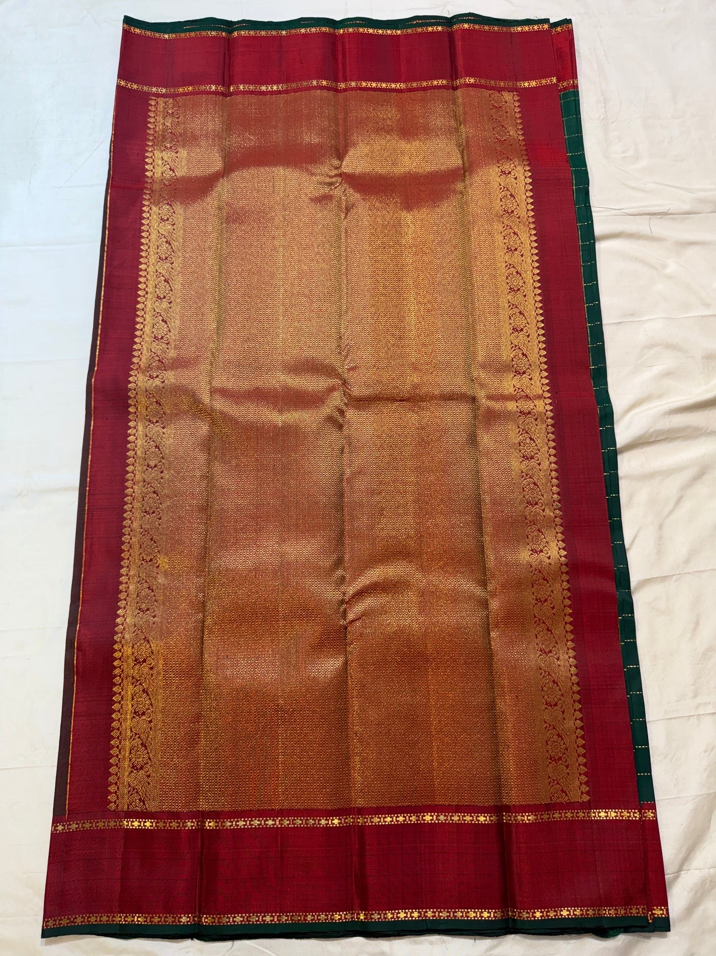 Close body detail showing pearl-like dotted zari lines crossing the dark green silk