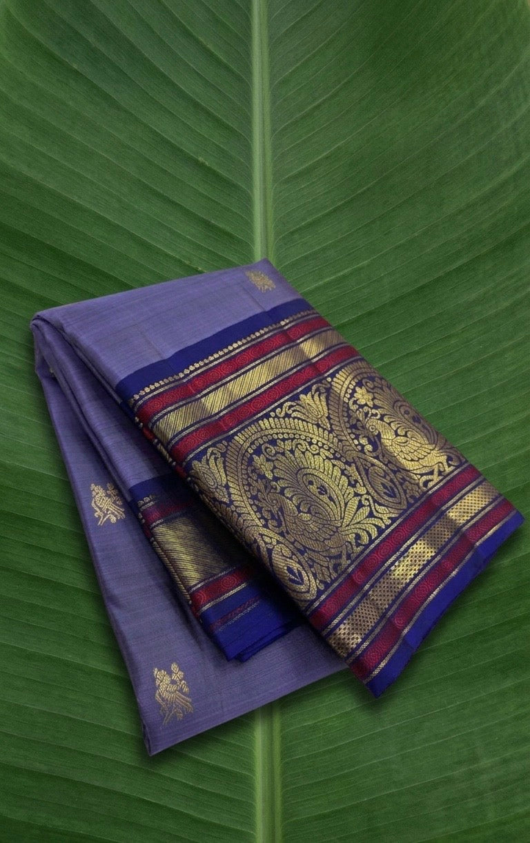 Mysterious purple Kanjivaram silk saree with violet korvai border and sorgavaasal mayil motif – front view