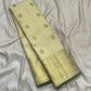 Handwoven warm ivory Zari Kattam Kanjipuram saree with dark green selvedge and gold zari detailing