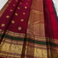 Folded navy blue Kancheepuram pure silk saree showing Yaanai Ambari Butta body and deep red Vanasringaram border