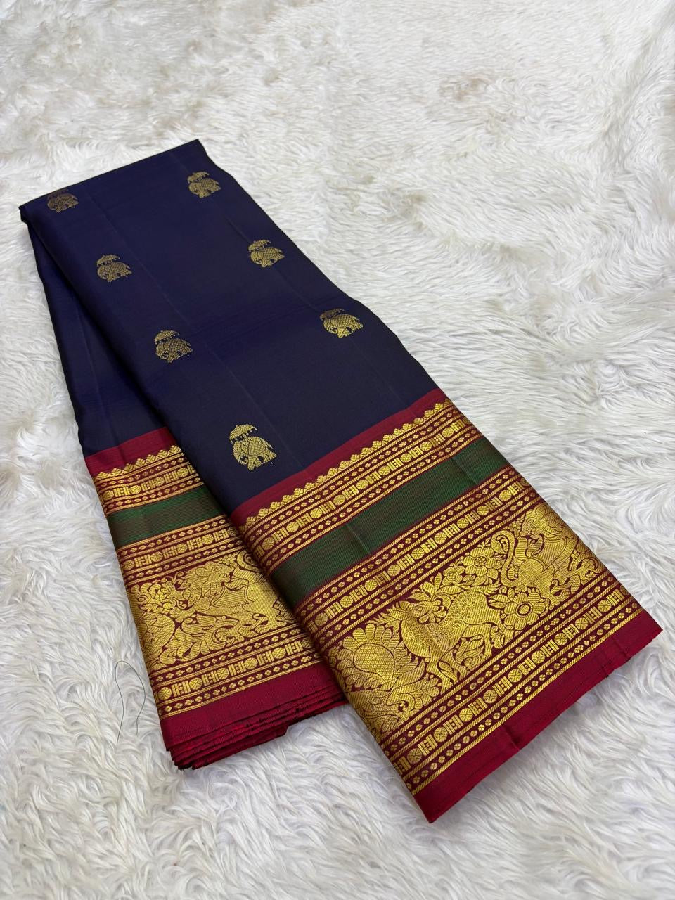 Handwoven navy blue Kancheepuram pure silk saree with gold zari Yaanai Ambari Butta and deep red Vanasringaram border