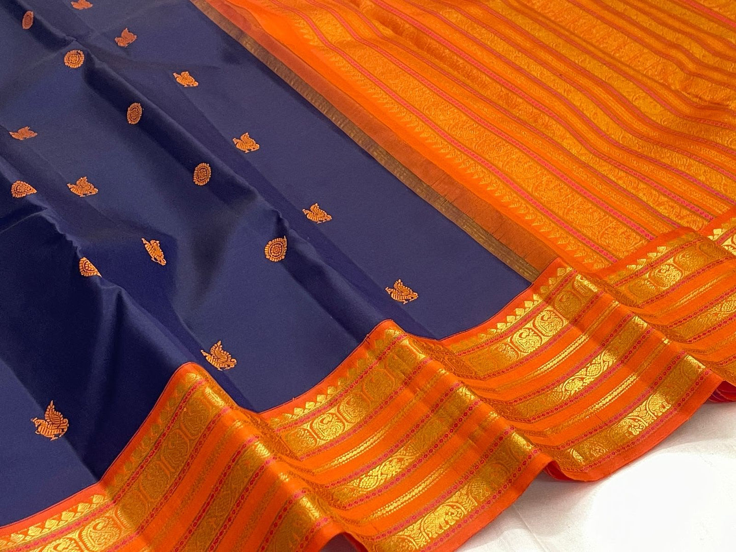 Handwoven navy Kanchipuram silk saree with orange Korvai border and gold zari
