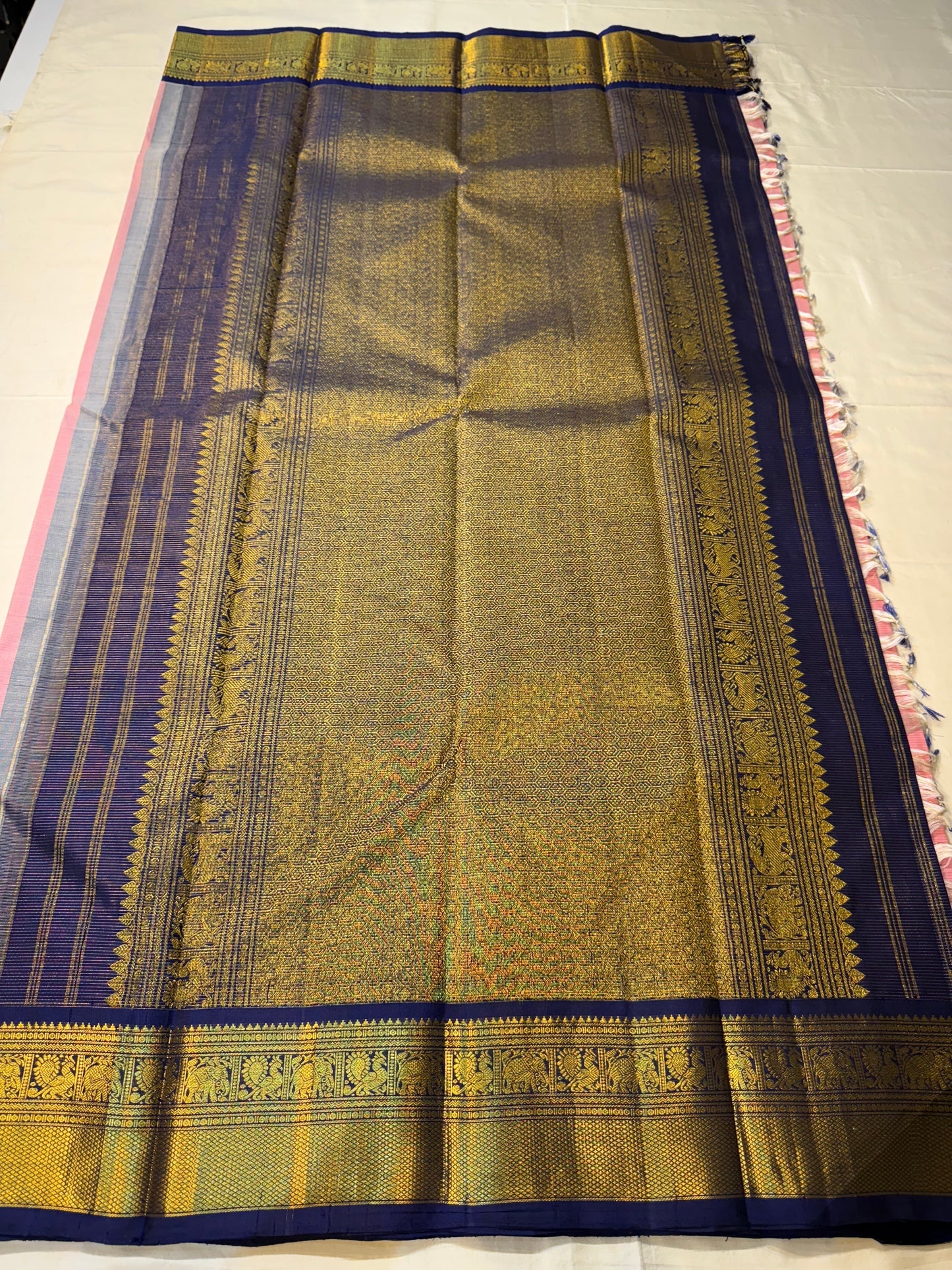 Full pallu layout of Kanchipuram silk saree in navy with antique gold zari woven field and tassels, available in the USA