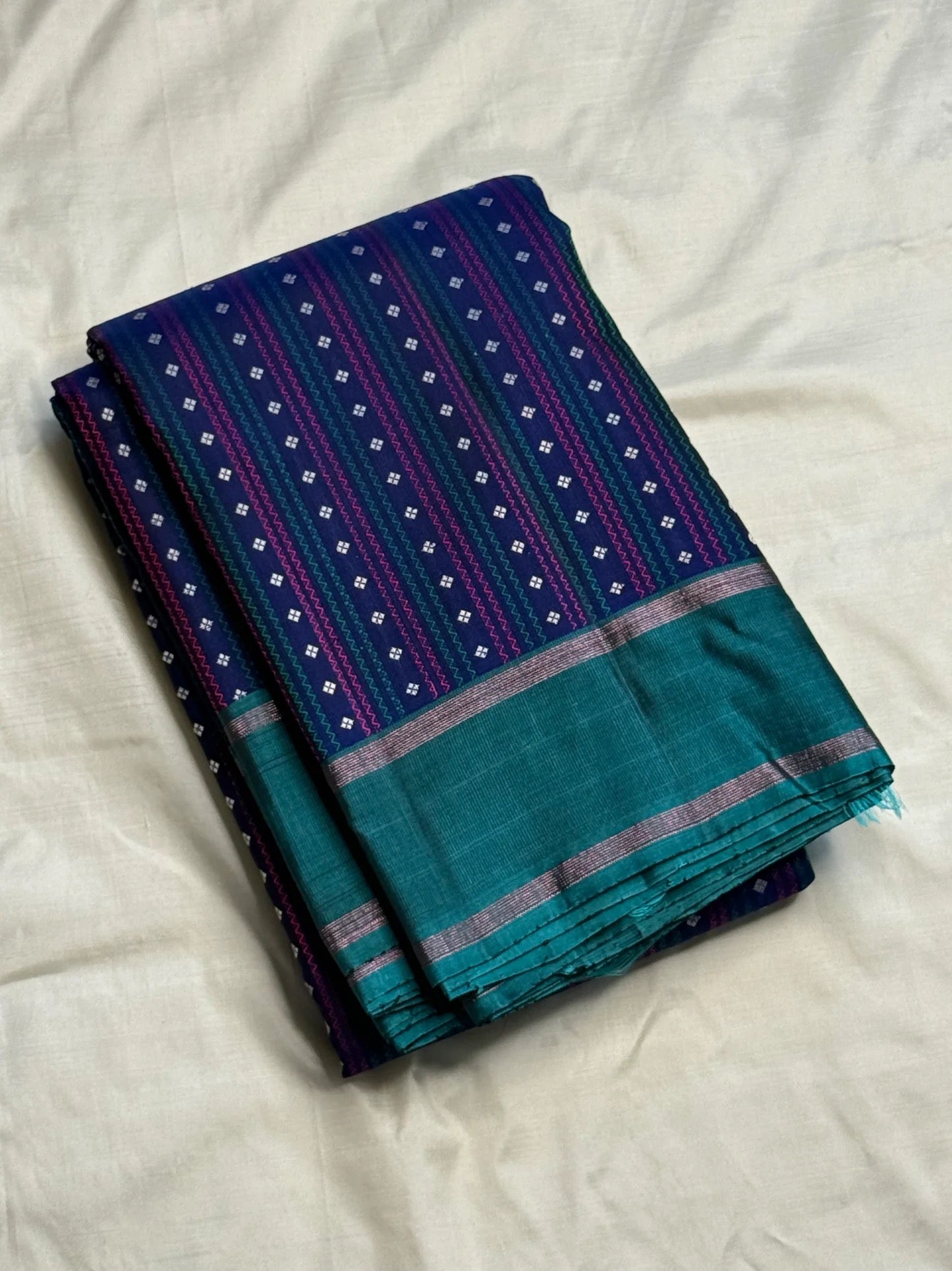 Teal-green silver zari pallu detail on navy Kanchi Pattu saree