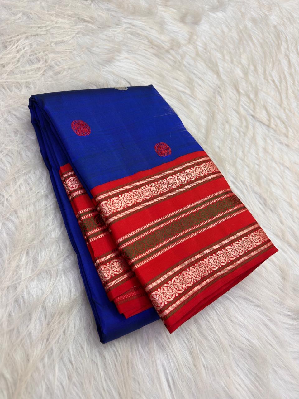 Folded Neelam blue pure silk Kanjivaram saree with red silk-thread Kamalam border and circular body buttas