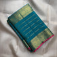 Teal Kanchipuram silk body with fine classic-gold zari lines forming a close ordered grid.