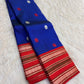 Neelam blue handwoven Pattupet Kanchipuram saree displayed open with contrasting red floral border and pallu