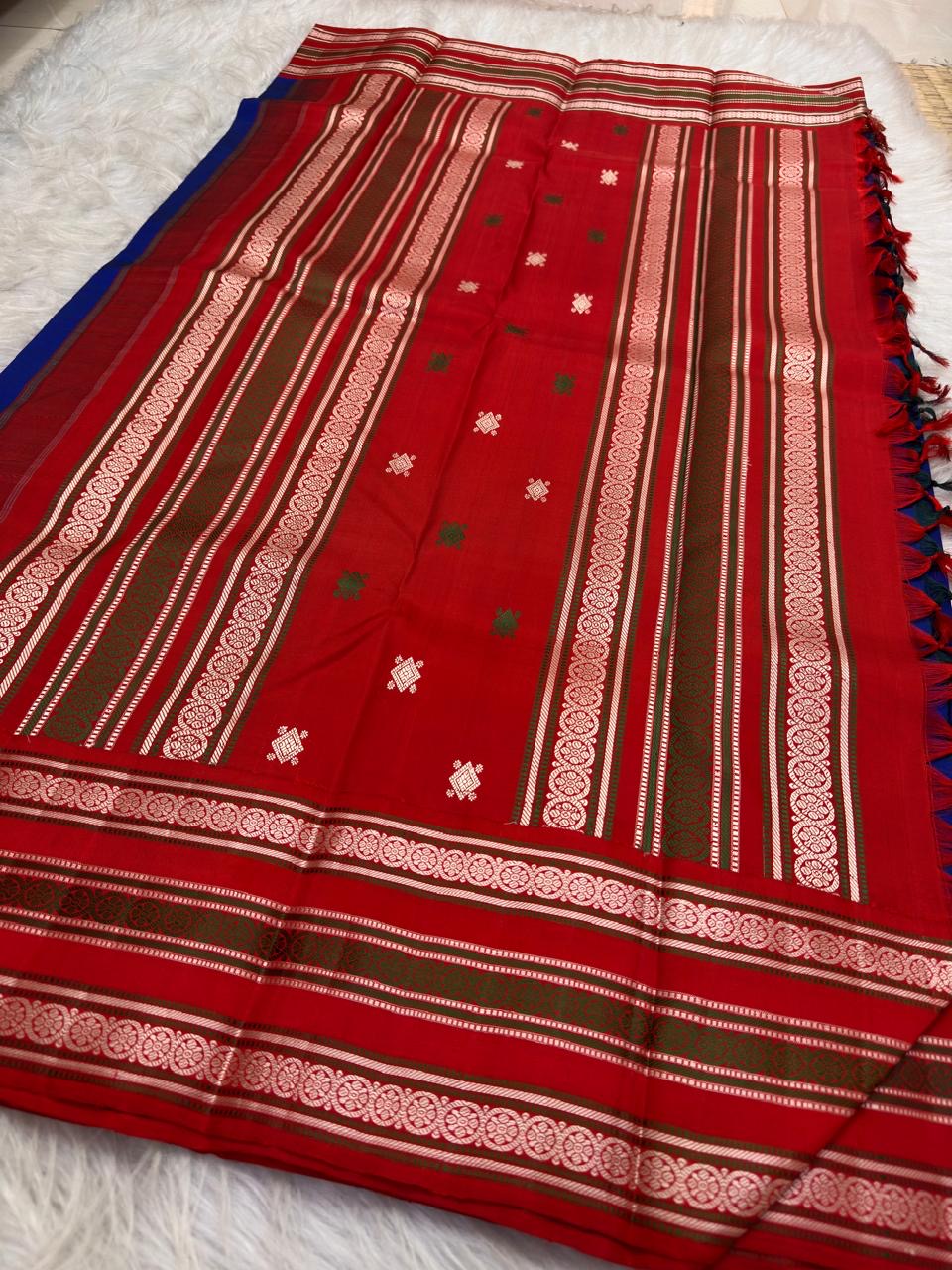 Neelam blue silk body with spaced circular Kamalam buttas alternating in red and jasmine-white thread