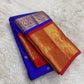 Royal blue Kanchipuram silk body with individually spaced classic-gold zari buttas across an open silk field.