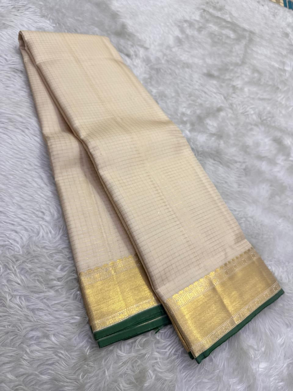 Thick antique gold zari woven border with floral and geometric motifs on off-white KanchiPattu saree